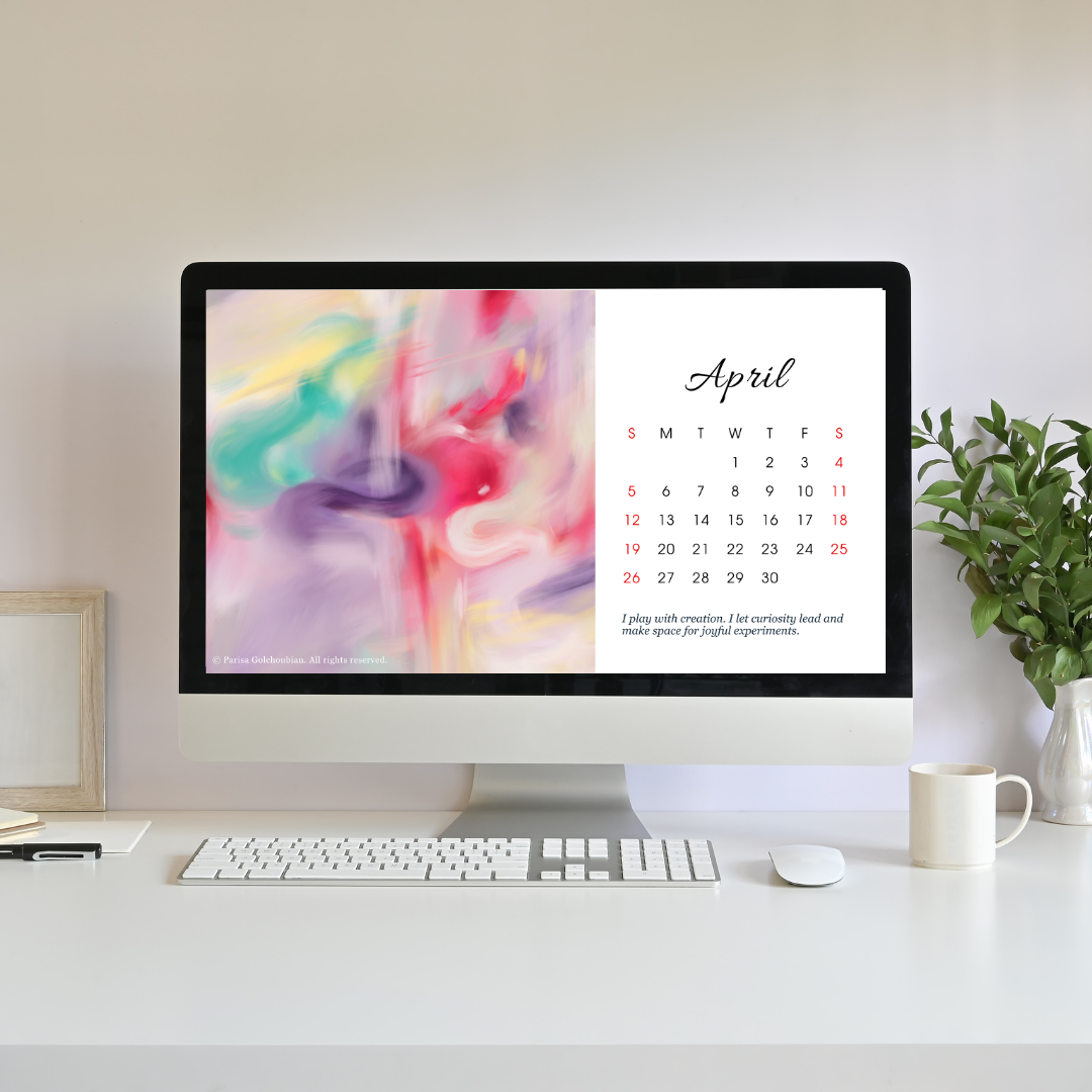 Computer monitor displaying an April calendar on a desk with a plant and mug.